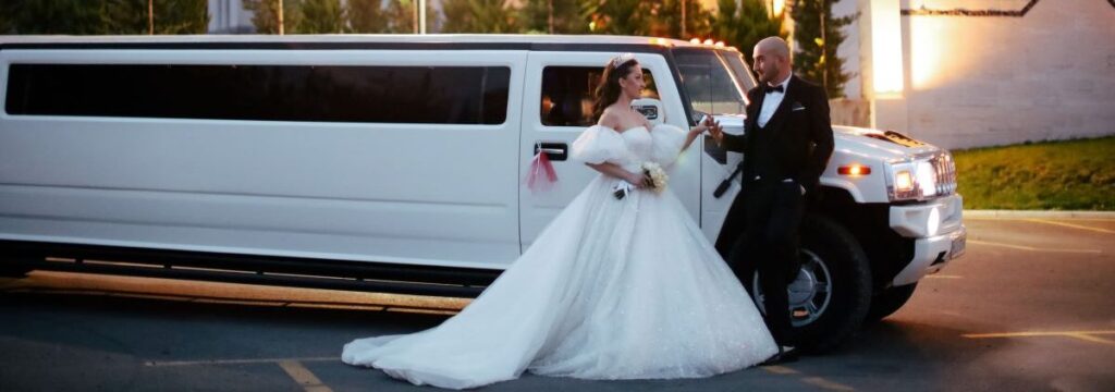 Bride and groom with white Hummer limo